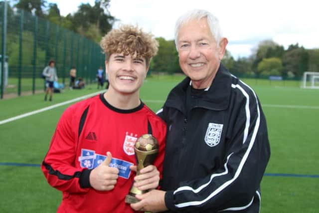 Nene Park Academy skipper Bradley Rolt receives the trophy from referee Stewart Francis. Picture: RWT Photography