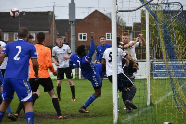 A goalmouth scramble in the match between Peterborough Sports and Corby. Photo: James Richardson.