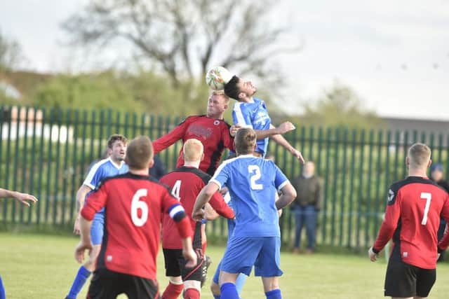 Netherton goal hero Karl Gibbs (red) challenges for a cross in the Whittlesey area. Photo: David Lowndes.
