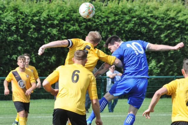 Tom Waumsley (blue) scored the only goal of the game for Yaxley at Kirby Muxloe.