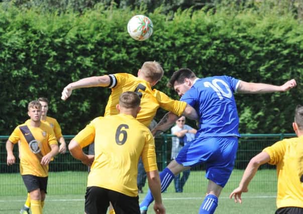 Tom Waumsley (blue) scored the only goal of the game for Yaxley at Kirby Muxloe.