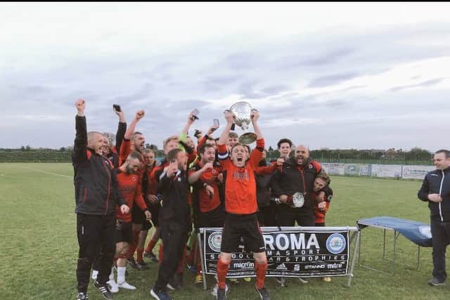 Netherton United skipper Ash Jackson celebrates with the Peterborough Premier Division trophy after last night's win over Whittlesry Athletic.