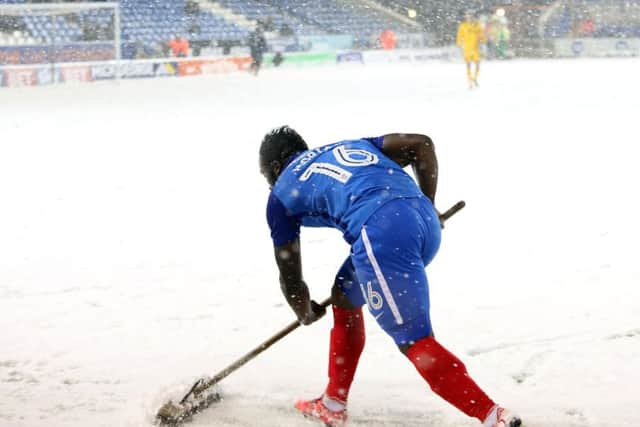 Junior Morias clearing snow off the Posh pitch.