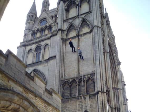 The Dean of Peterborough the Very Rev Chris Dalliston and chief executive of Peterborough City Council Gillian Beasley abseil down the Cathedral