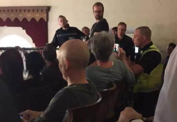 Police in the public gallery during a vocal protest against Cllr Andy Coles