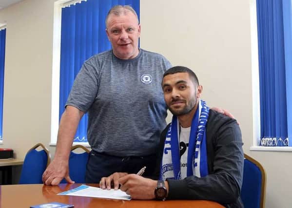 Colin Daniel signs for Posh watched by manager Steve Evans. Picture: Joe Dent.