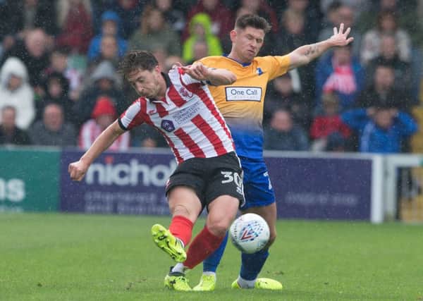 New Posh signing Alex Woodyard (left) in action for Lincoln City.