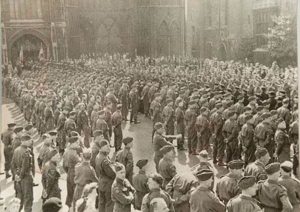 A large gathering of troops by the west front of the cathedral to celebrate victory in Europe