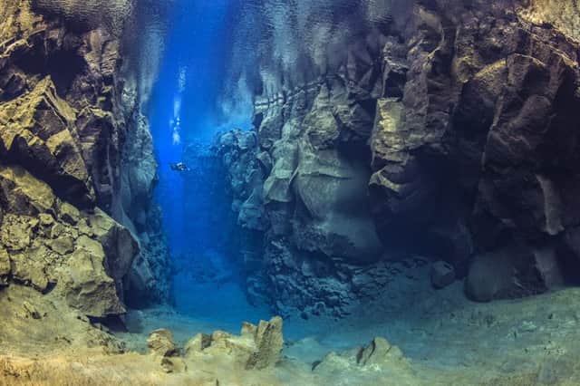 A diver explores the cathedral at Silfra canyon, a deep fault filled with fresh water in the Rift Valley between the Eurasian and American tectonic plates, at Thingvellir National Park, Iceland. In this photo the American plate is on the left and the Eurasian plate on the right.