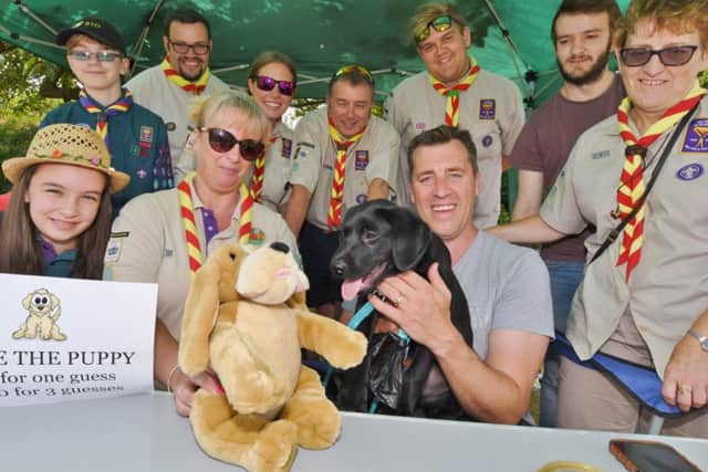 All Saint's church, Paston 800 year celebrations fete at Itter Park.  Paston scouts  with their guess the name of the puppy stall with Jack the black labrador EMN-170807-175651009
