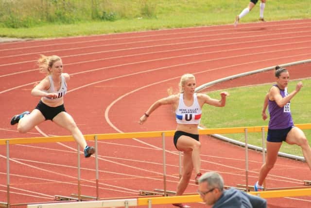 Rosie Jacobs (left) and Emily Maltby in hurdles action.