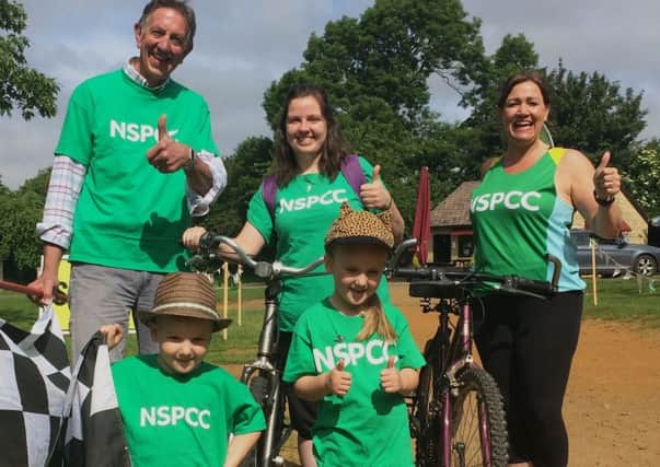 Chris Quinn waves the flag with NSPCC fundraising co-ordinator Rose OSullivan and regional community fundraising manager Sarah Lambley with young supporters Elliott and Isla.