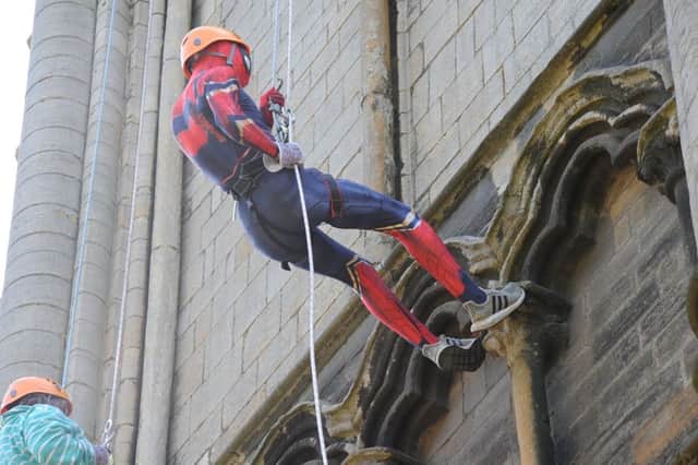 A person dressed as Spiderman abseiling down Peterborough Cathedral EMN-180519-082616009
