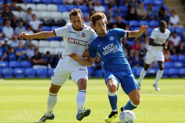 Alex Woodyard of Posh battles with Bolton's Adam Le Fondre. Photo: Joe Dent/theposh.com.
