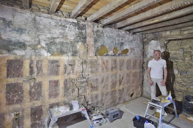 The Painted Room uncovered at a hotel conversion at Broad Street, Whittlesey. Pictured is  Simon Black looking at the   1650's artwork EMN-180731-150447009
