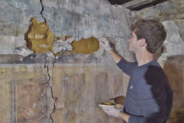 The Painted Room uncovered at a hotel conversion at Broad Street, Whittlesey. Pictured is Sam Whittaker renovating some of the holes in the artwork EMN-180731-150511009