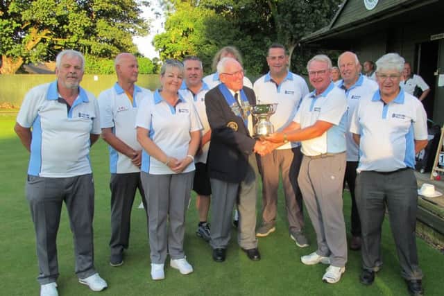 Blackstones captain Mel Smith receives the Albert Rowlett Cup from Peterborough League president Dick Gill watched by his team-mates (from the left) Sam Downs, Peter Linnell, Rita Downs, Michael Humphreys, Paul Bailey, Jon Earl, Roger Martin and Paul Buckley.