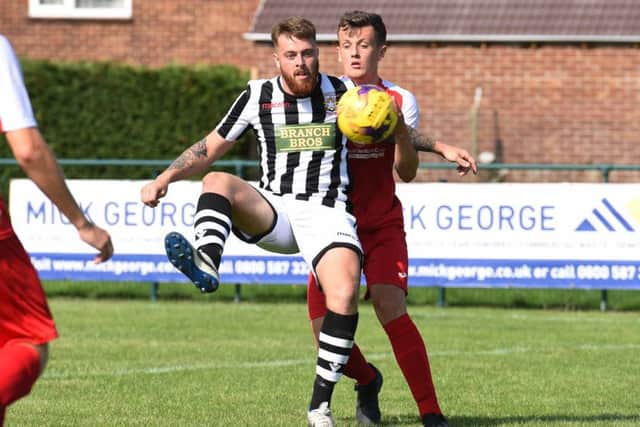 Josh Rosser (stripes) of Peterborough Northern Star in action against Fakenham Town. Photo: Chantelle McDonald. @cmcdphotos.
