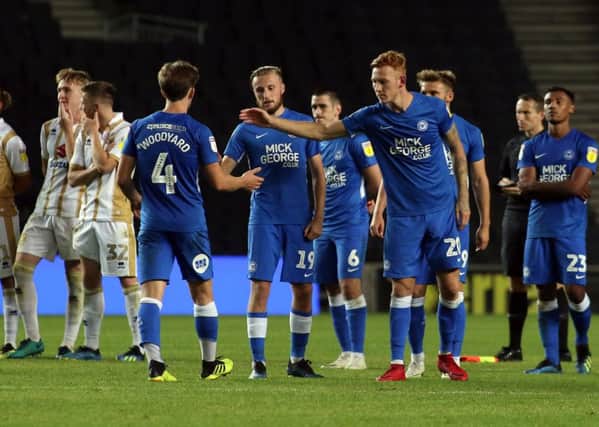 Posh substitute Alex Woodyard is consoled by team-mates after seeing his penalty in the shootout at MK Dons saved. Photo: Joe Dent/theposh.com.