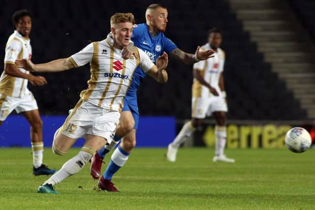 Marcus Maddison of Peterborough United in action with Ryan Watson of MK Dons. Photo: Joe Dent/theposh.com.
