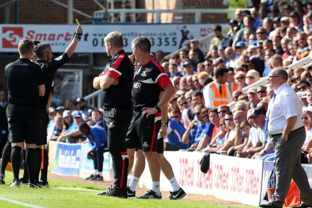 Match referee Darren Bond brandishes a yellow card in the direction of the Posh bench during the draw against Doncaster. Photo: Joe Dent/theposh.com.