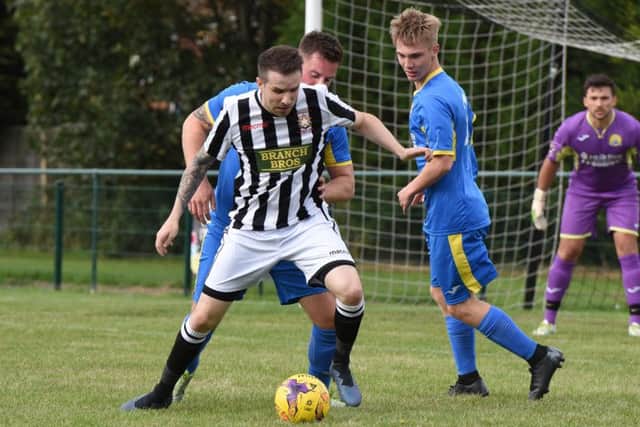Matt Barber (stripes) of Peterborough Northern Star in action against March Town. Photo: Chantelle McDonald. @cmcdphotos