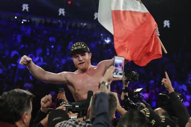 Canelo Alvarez celebrates after defeating Gennady Golovkin by majority decision in a middleweight title boxing match.