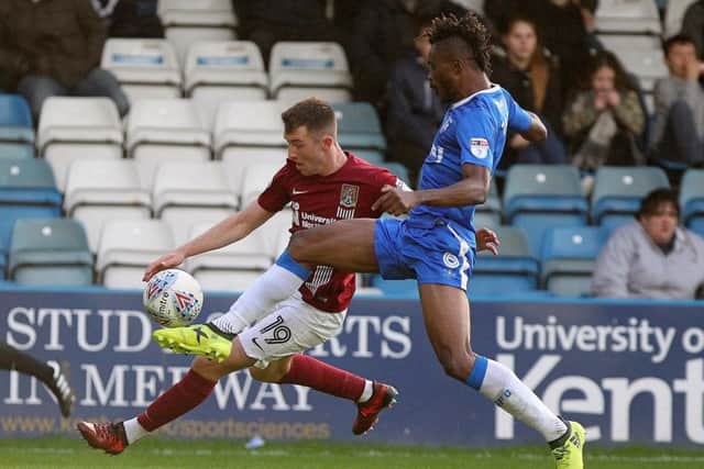 Former Posh defender Gaby Zakuani (blue) in action for Gillingham.