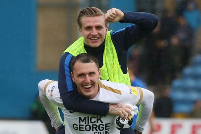Unused substitute Jason Cummings helps Posh goalscorer Callum Cooke celebrate at the end of the 4-2 win at Gillingham. Photo: Joe Dent/theposh.com.