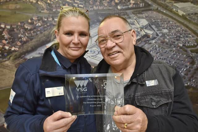 Heart attack survivor Frank Dawson hands an award to staff at Serpentine Green who saved his life. Sam Elsworth is pictured with him EMN-180310-083208009