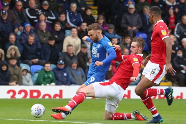 Matt Godden of Peterborough United is tackled by Liam Lindsay of Barnsley. Photo: Joe Dent/theposh.com