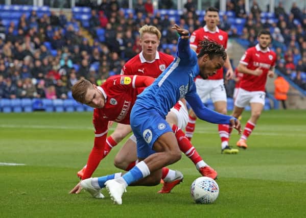 Ivan Toney of Peterborough United in action with Liam Lindsay of Barnsley. Photo: Joe Dent/theposh.com
