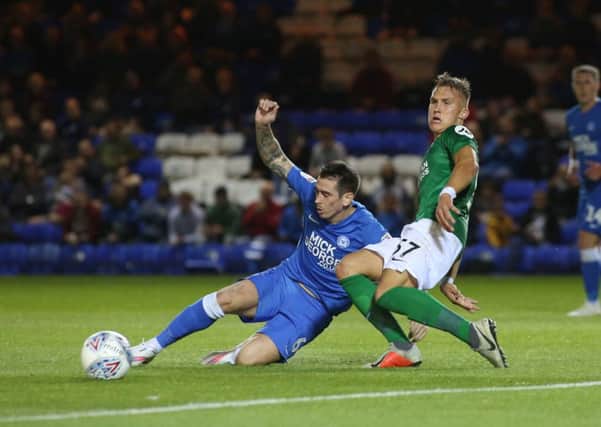 Jamie Walker slides in to a tackle for Posh against Brighton. Photo: Joe Dent/theposh.com.