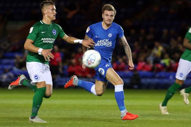 Jason Cummings of Peterborough United in action with Leo Ostigard of Brighton & Hove Albion. Photo: Joe Dent/theposh.com.