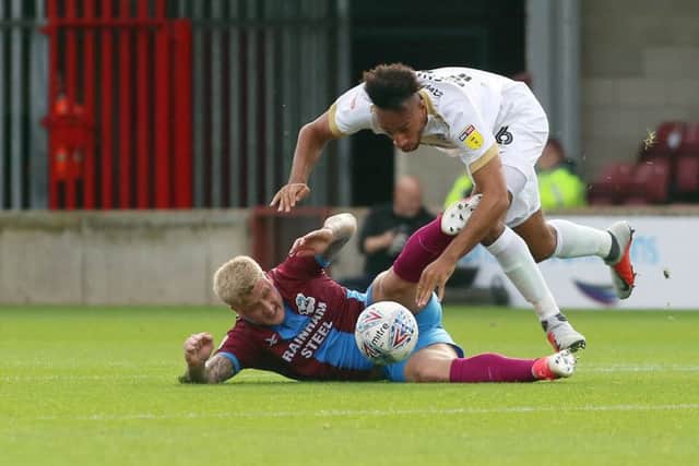 Rhys Bennett of Peterborough United in action with Stephen Humphrys of Scunthorpe United. Photo: Joe Dent/theposh.com.
