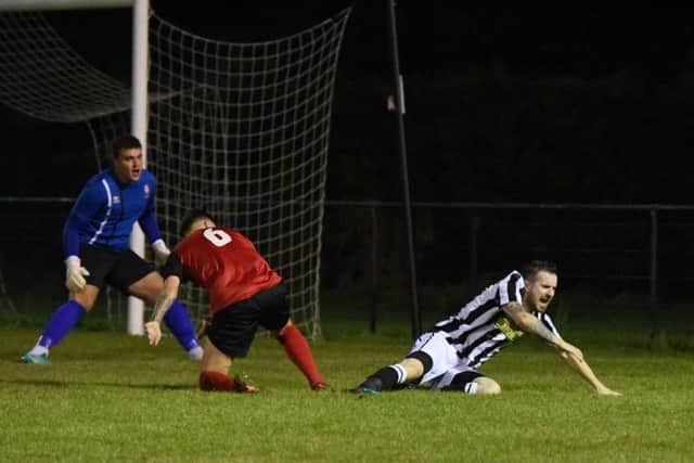 Matthew Barber (stripes) of Peterborough Northern Star wins a penalty against Sleaford Town. Photo: Chantelle McDonald. @cmcdphotos