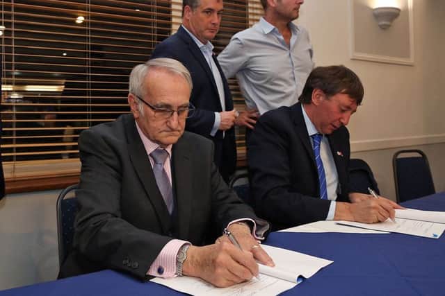 Peterborough City Council leader John Holdich (left) and Posh co-owner Dr Jason Neale sign the papers which moved the ABAX Stadium close to returning under the club's control. Photo: Joe Dent/theposh.com.