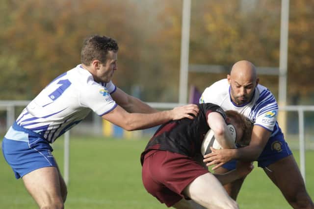 Allen Carr (left) and Shaquille Meyers get to grips with a Huddersfield player. Picture: Mick Sutterby