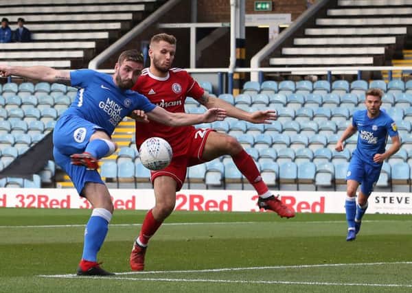 Jason Naismith of Peterborough United shoots at goal while under pressure from Nick Anderton of Accrington Stanley. Picture: Joe Dent