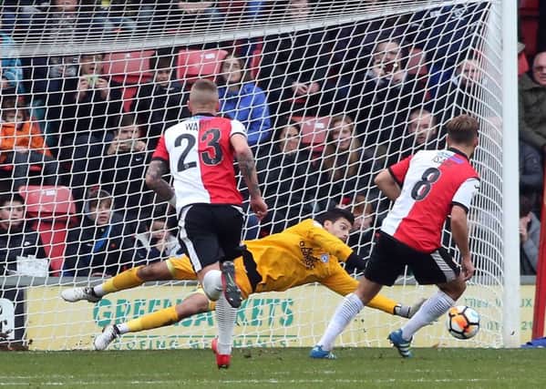 Posh goalkeeper Jonathan Bond saves a penalty in an FA Cup tie at Woking last season.