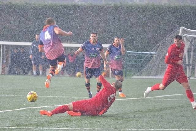 Action in the rain as Yaxley took on Wisbech (red) in the FA Trophy. Photo: David Lowndes.