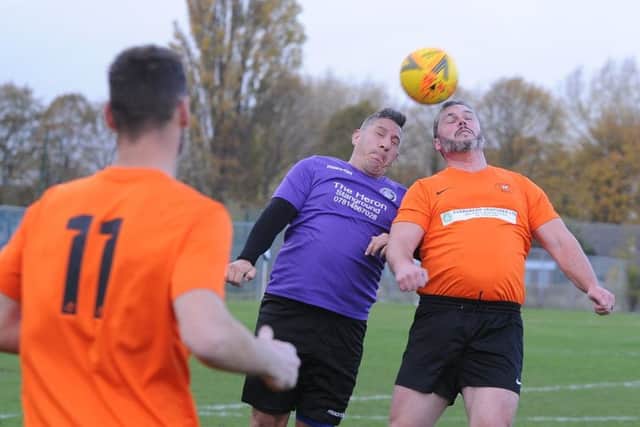 An aerial duel in the Peterborough Division Five game between Stanground Sports (purple) and Leverington Sports A. Photo: David Lowndes.
