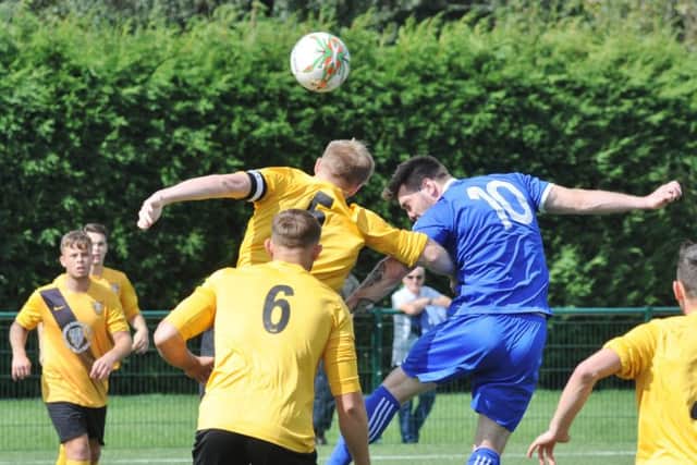 Tom Waumsley (blue) equalised for Yaxley against Ramsbottom.