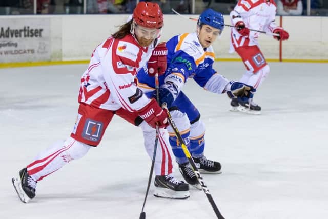 Corey McEwen holds off Steve Whitfield of the Wildcats. Picture: Tom Scott