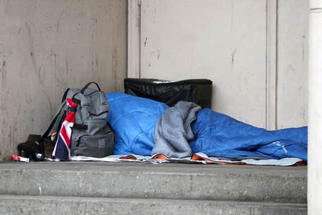 A homeless person sleeping rough in a doorway.