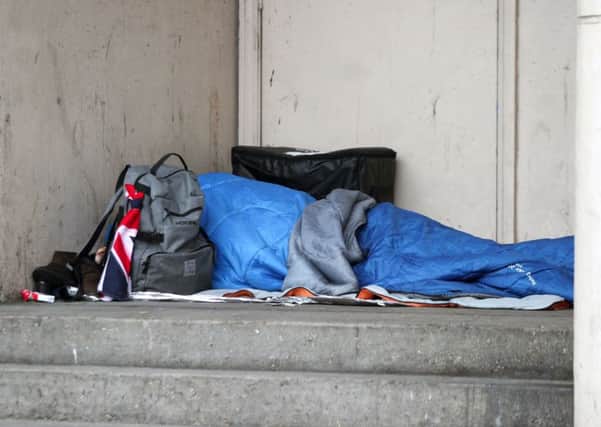 A homeless person sleeping rough in a doorway.