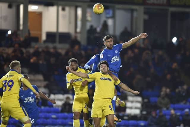 Ryan Tafazolli climbs highest for Posh against Wimbledon. Photo: David Lowndes.