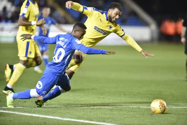 Posh winger Siriki Dembele goes down in the Wimbledon penalty area. Photo: David Lowndes.