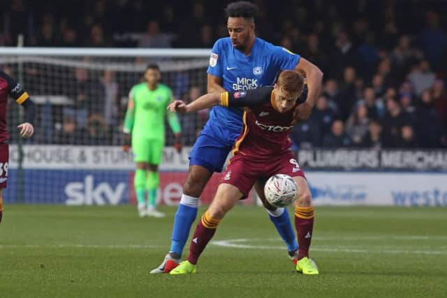 Rhys Bennett of Peterborough United gets to grips with Eoin Doyle of Bradford City. Photo: Joe Dent/theposh.com.