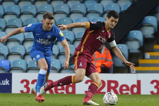 Matt Godden of Peterborough United puts Anthony O'Connor of Bradford City under pressure. Photo: Joe Dent/theposh.com.